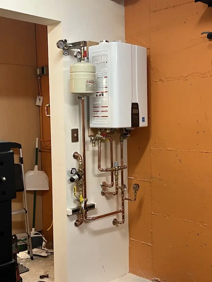 Plumbing technician inspecting water heater connections in West Carrollton